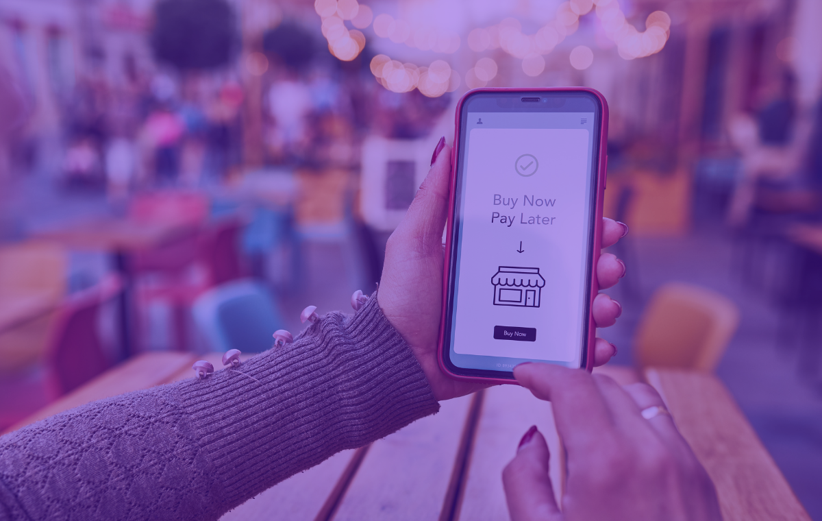 A hand holding a mobile phone with Buy Now Pay Later on the screen