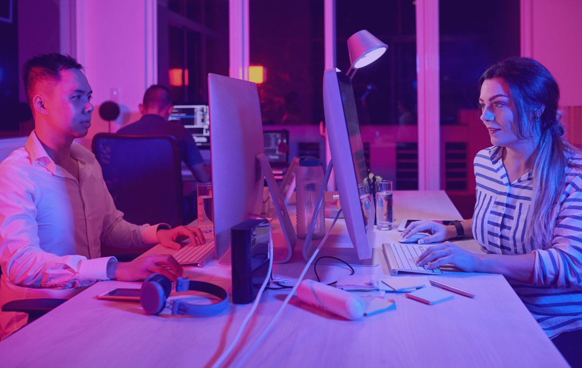 Two developers working on performance monitoring on desktops