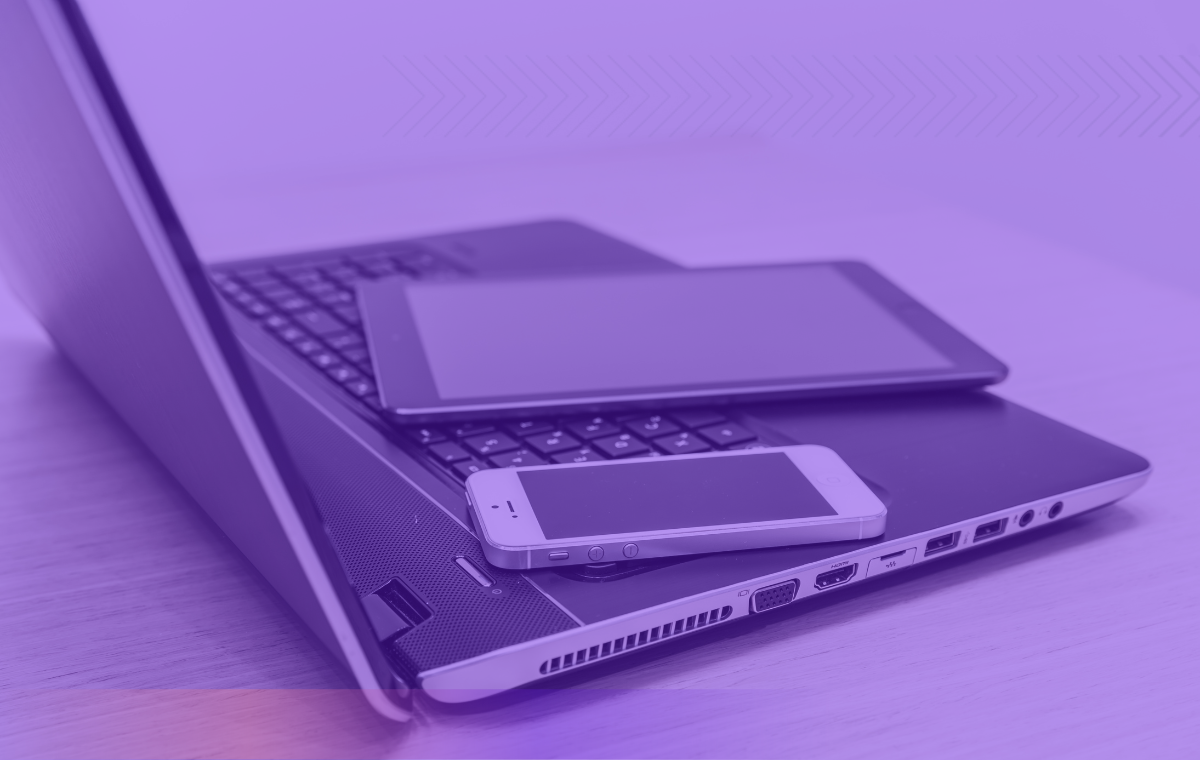 A laptop with a tablet and mobile phone on it.